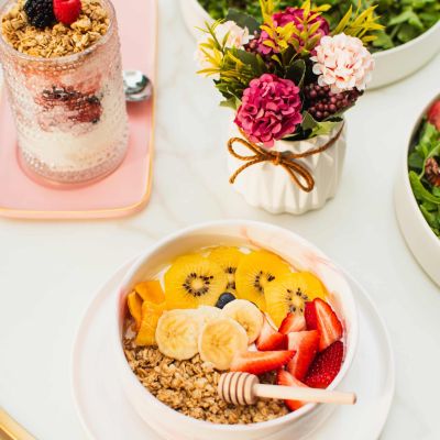 Brunch table at La Vie Belle Miami Beach with a yogurt bowl, fresh salad and iced matcha latte